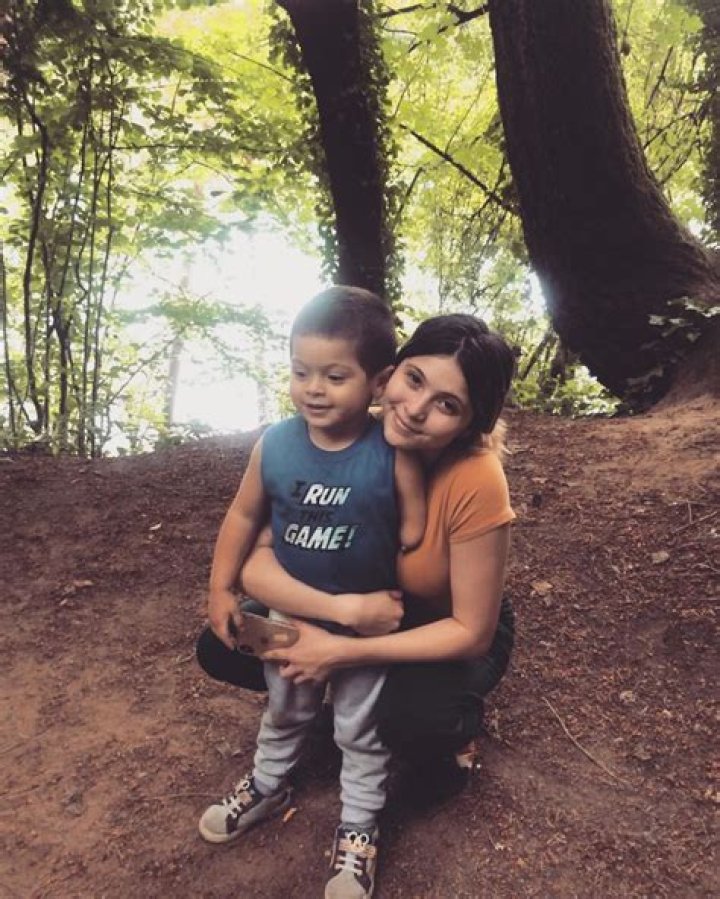 Both Brianna Jaramillo and Braeson are sitting in a swing.