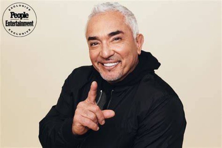 Cesar Millan in a black lined coat with his wife in a black bodycon with yellow flowers printed on it.