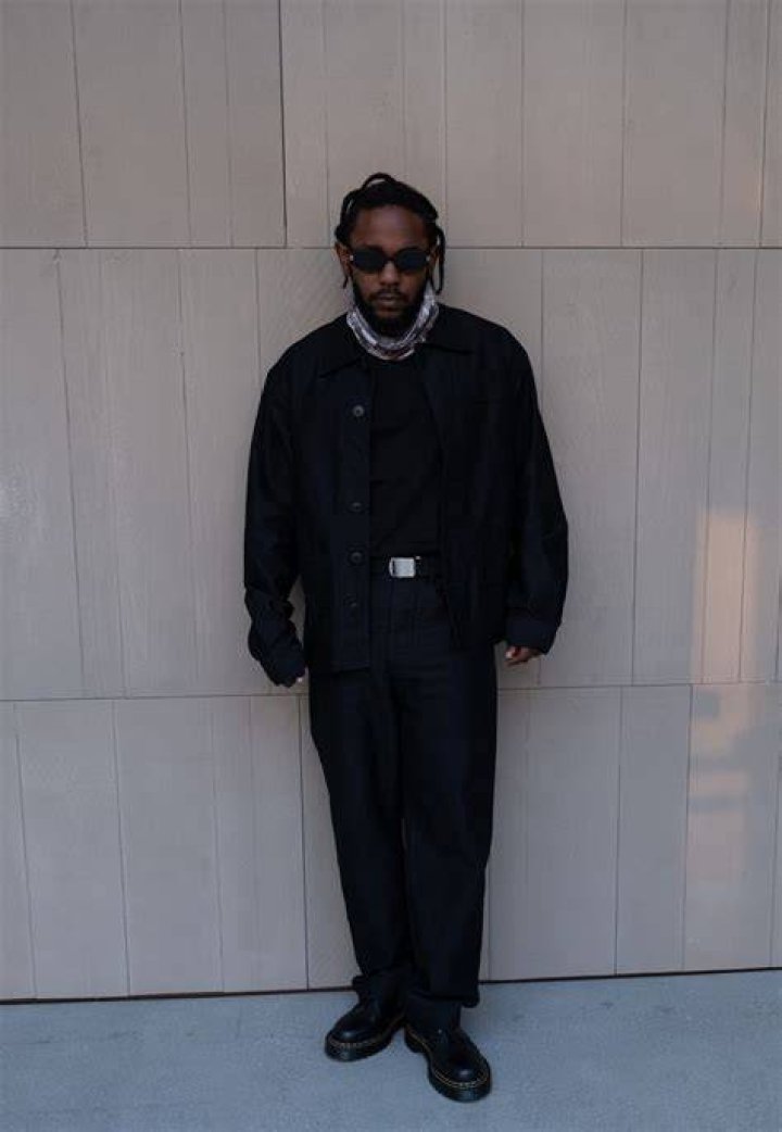Lamar wearing black suit with white shirt .